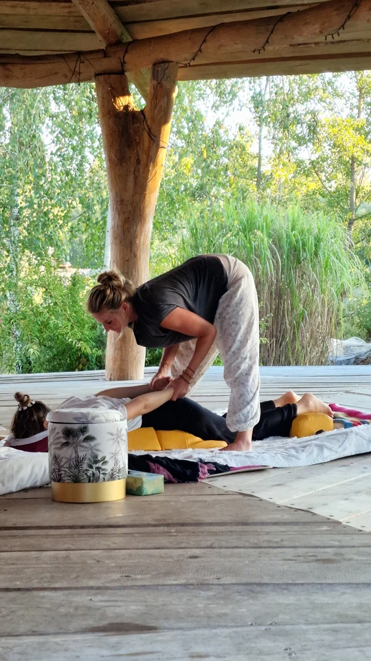 Daniela bei einer Shiatsu-Behandlung auf einer Matte unter dem Holzdach der Seebühne